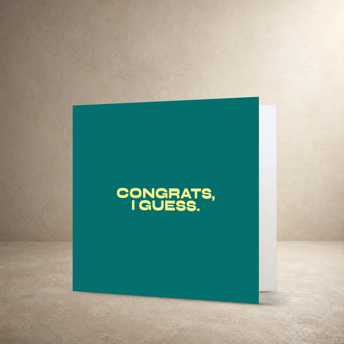Teal card front with bold pale yellow centred typography, with the message: “Congrats, I guess.”.