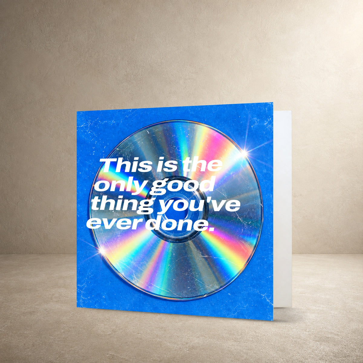 Scratched iridescent CD on a vivid blue textured background, with the message: “This is the only good thing you've ever done.”.