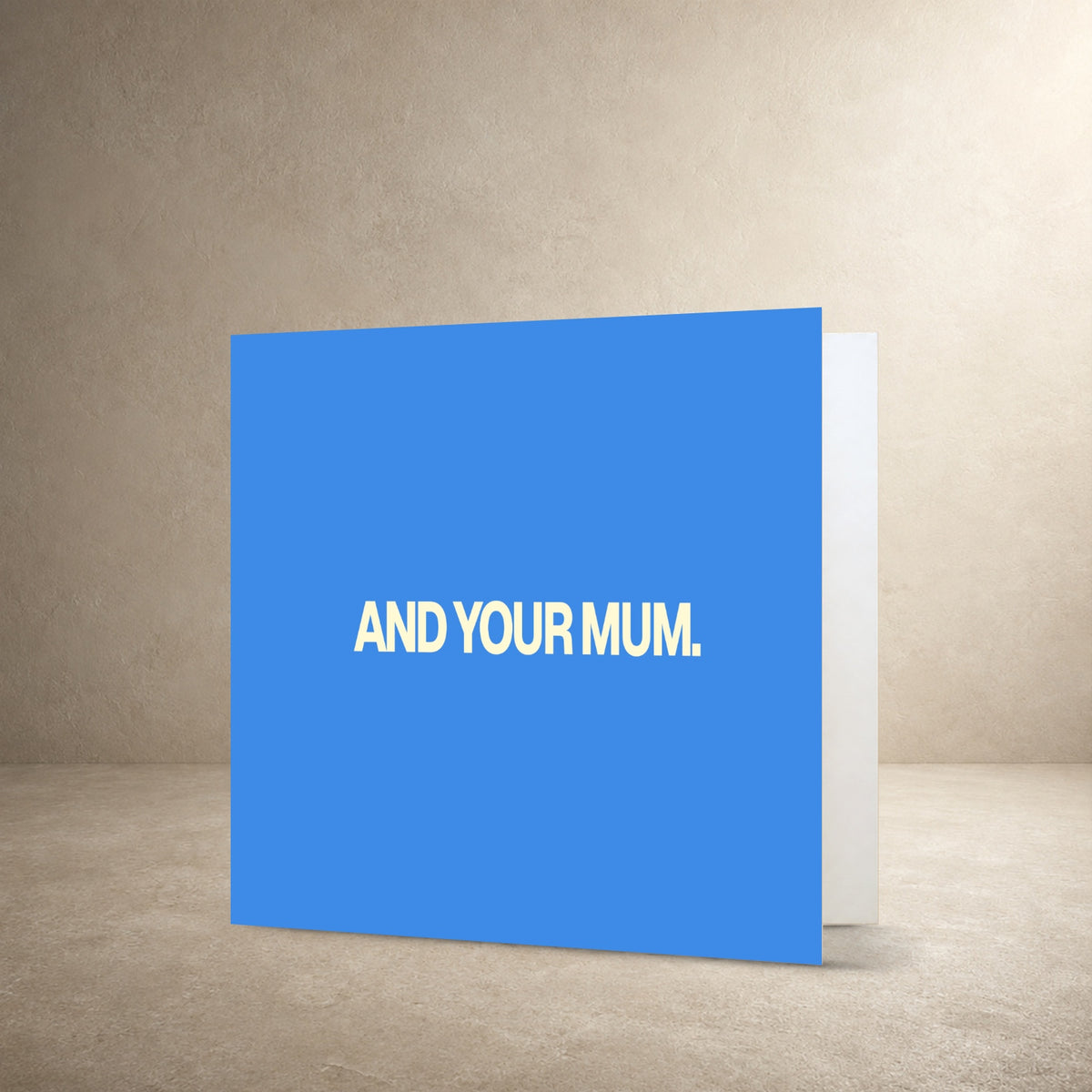 Light blue card front with bold cream centred typography, with the message: “And your mum.”.