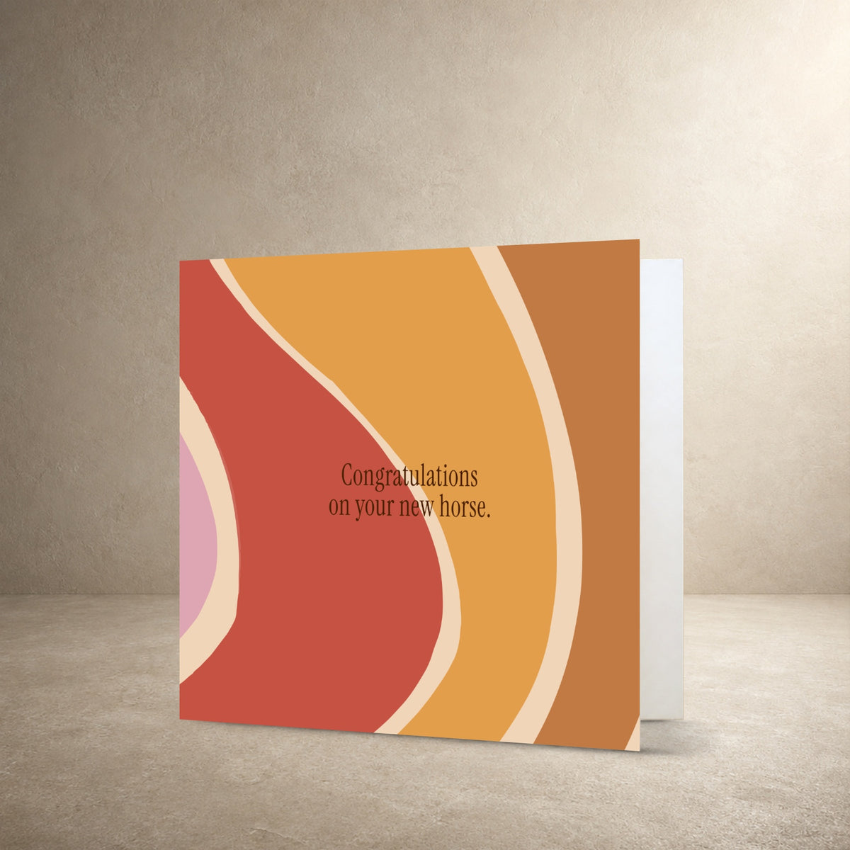 Retro abstract card front with flowing orange, cream, pink and rust-coloured stripes, with the message: “Congratulations on your new horse.”.