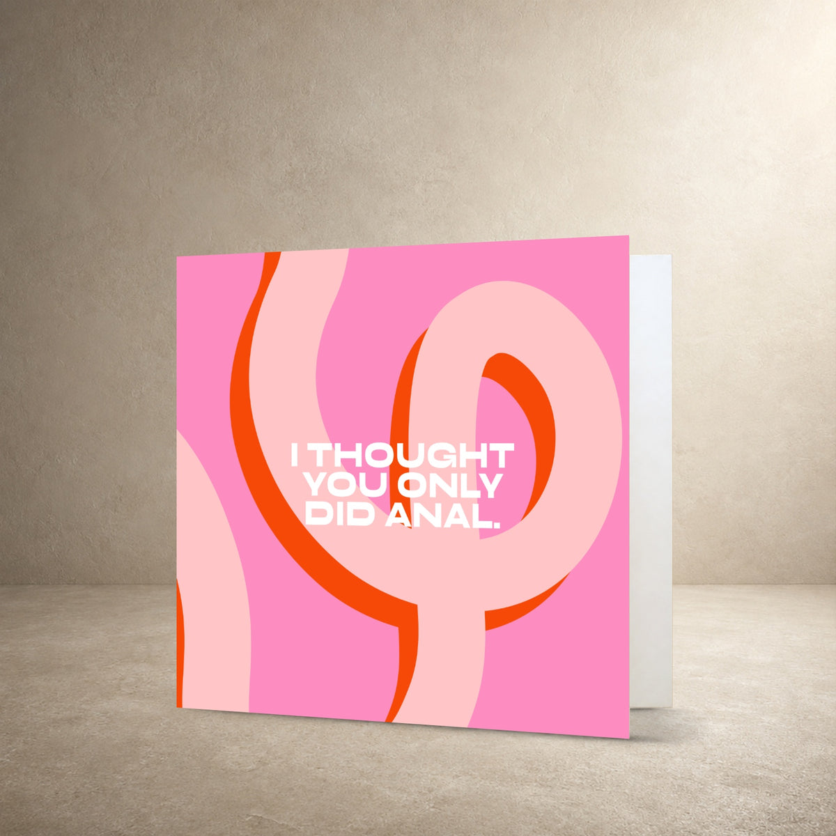 Bright pink card front with looping orange and pale pink abstract ribbon shapes, with the message: “I thought you only did anal.”.