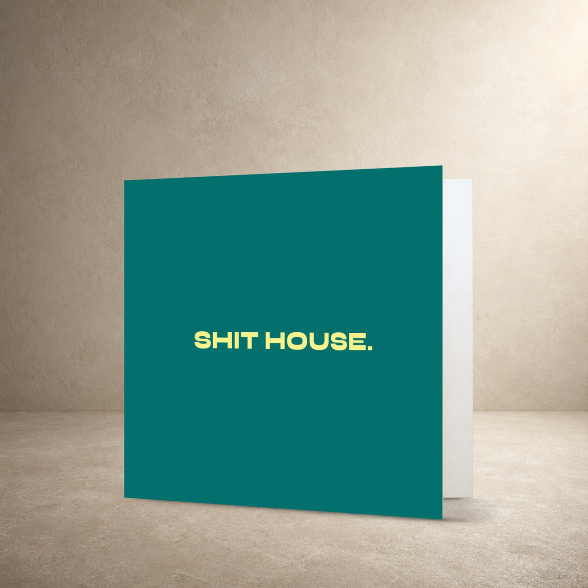 Teal card front with bold pale yellow centred typography, with the message: “Shit house.”.