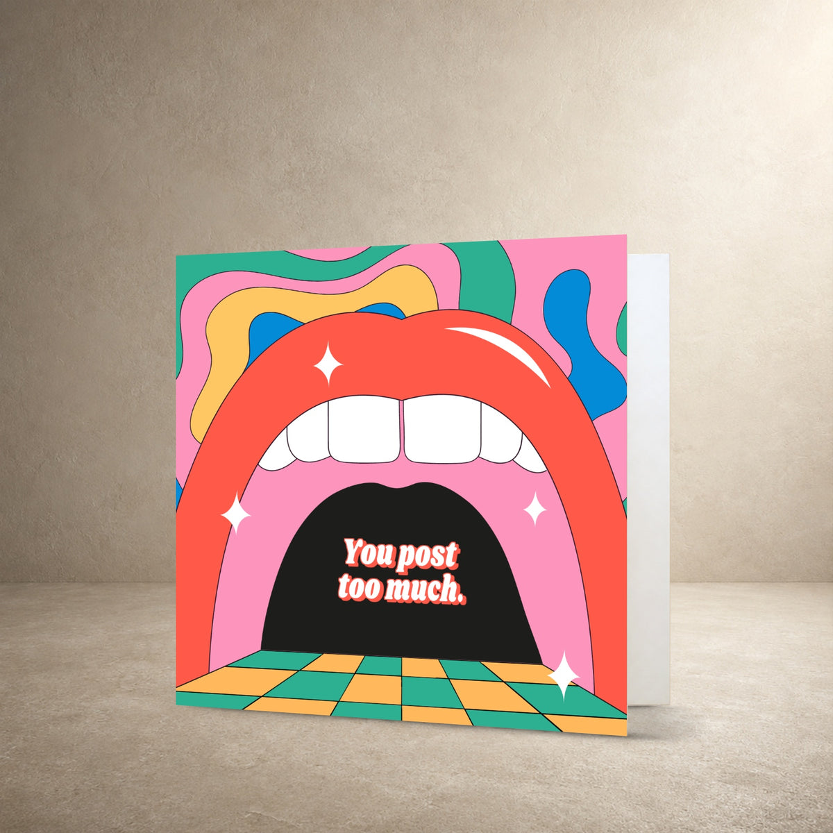 Psychedelic card front with a large illustrated red mouth, teeth and colourful retro shapes, with the message: “You post too much.”.