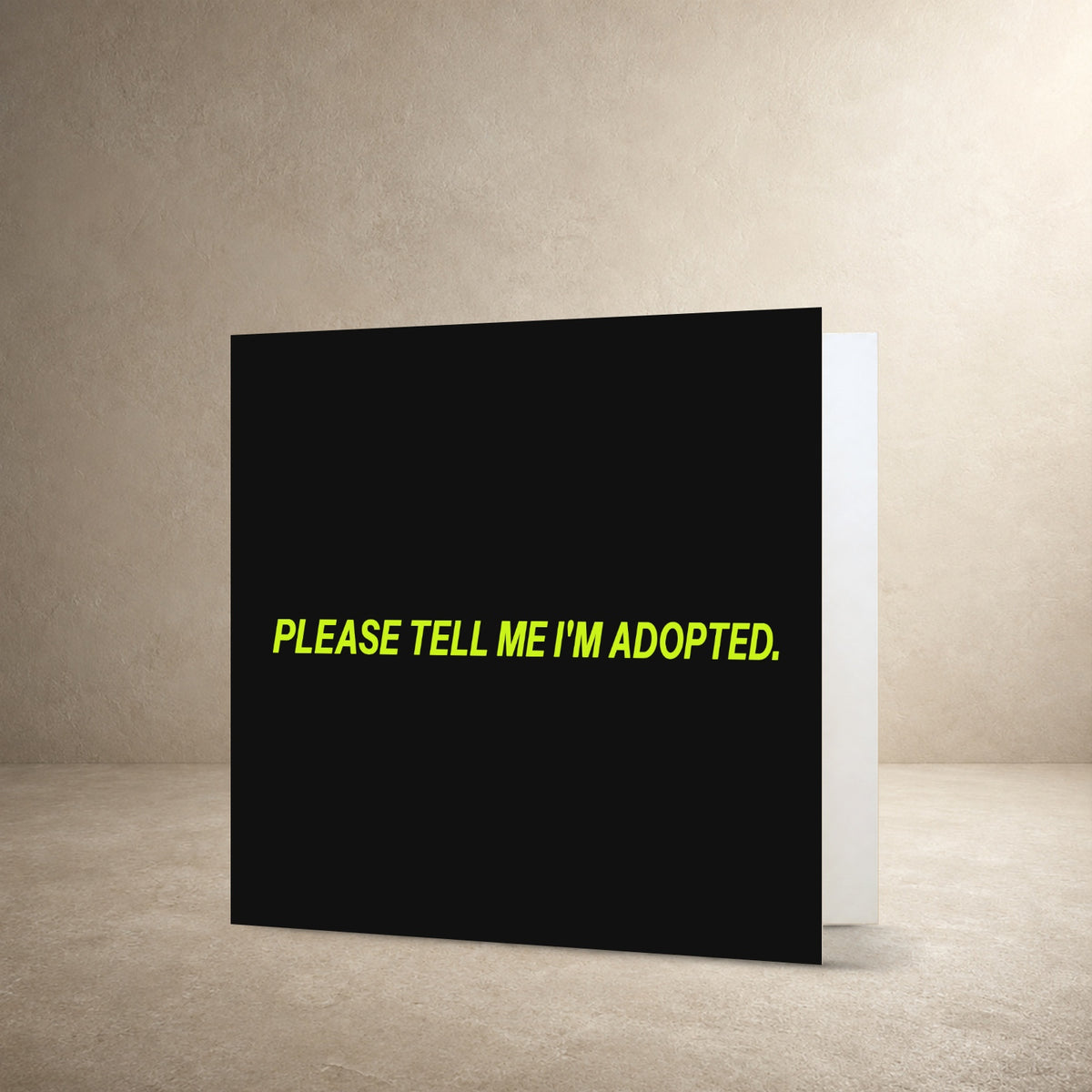 Minimal grey card front with bright lime centred typography, with the message: “Please tell me I'm adopted.”.