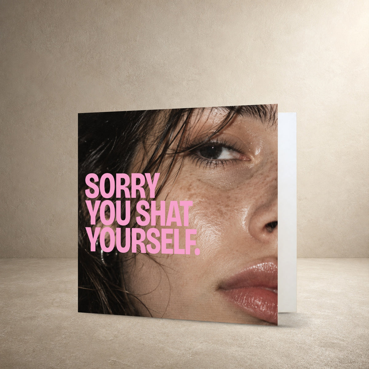 Close-up flash photograph of a face with dewy skin and dark hair, with the message: “Sorry you shat yourself.”.